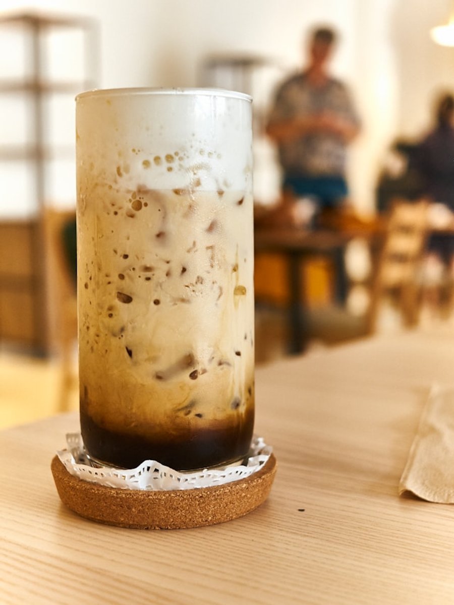 Iced latte served in a tall glass with a straw